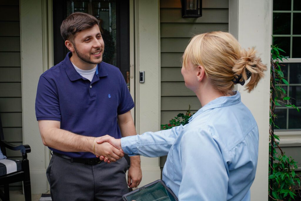 Customer shaking hands with lawn care technician