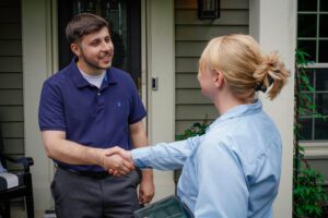 Customer shaking hands with lawn care technician