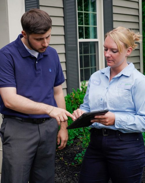 ExperigreenD1-55 Customer pointing to tablet with lawn care technician